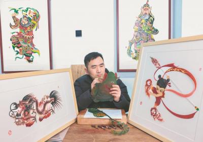 皮影非遗代表性传承人朱超在制作皮影作品